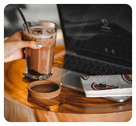 trabajando-con-cafe-o-cacao-en-vaso-de-cristal-con-ordenador-portatil-y-libro